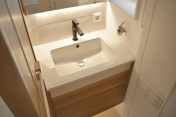 Compact bathroom design with a space-saving undermount sink on a 24-inch cabinet.