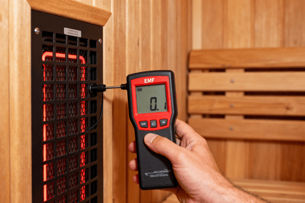 Person testing electromagnetic field EMF levels in an infrared sauna